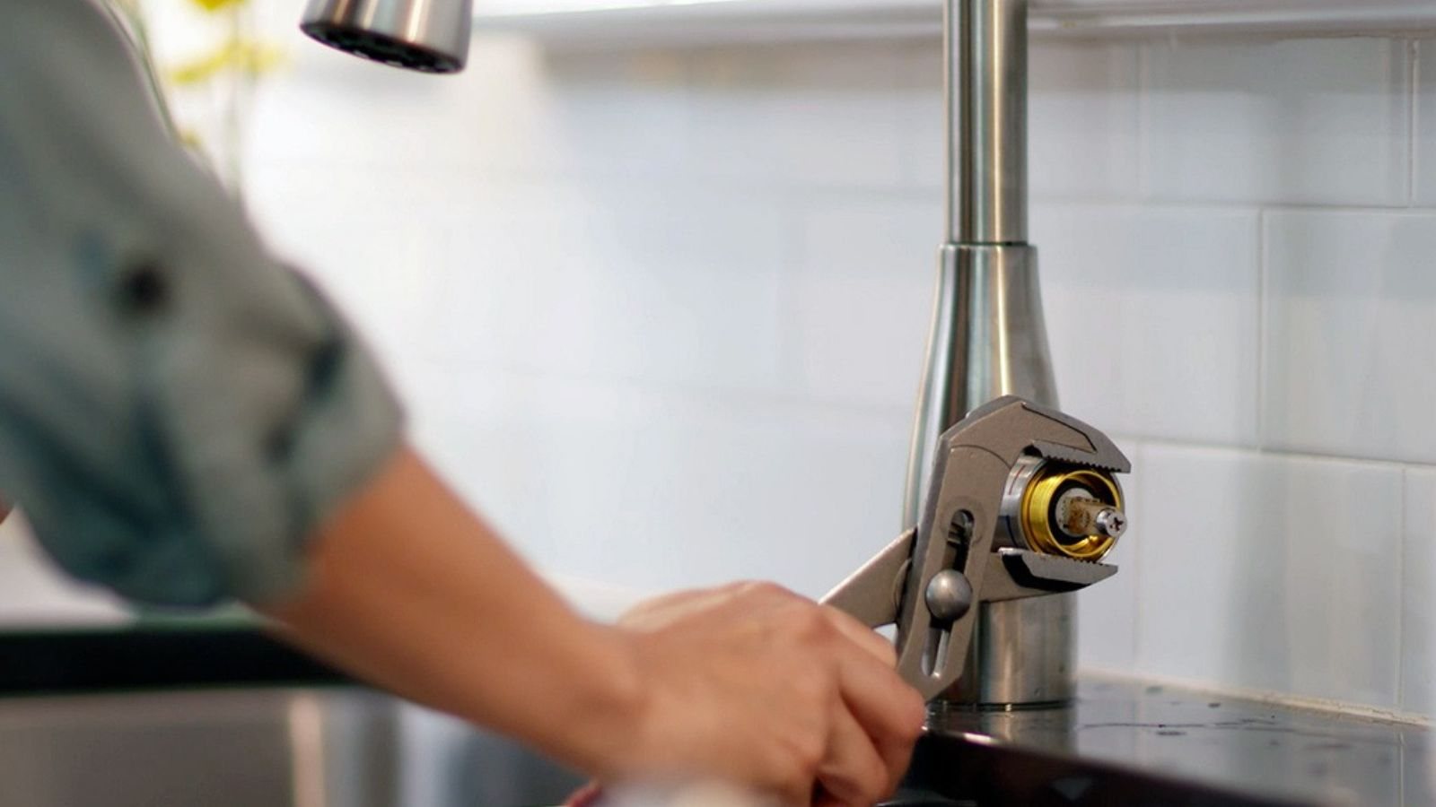 Technician repairing a kitchen faucet and sink