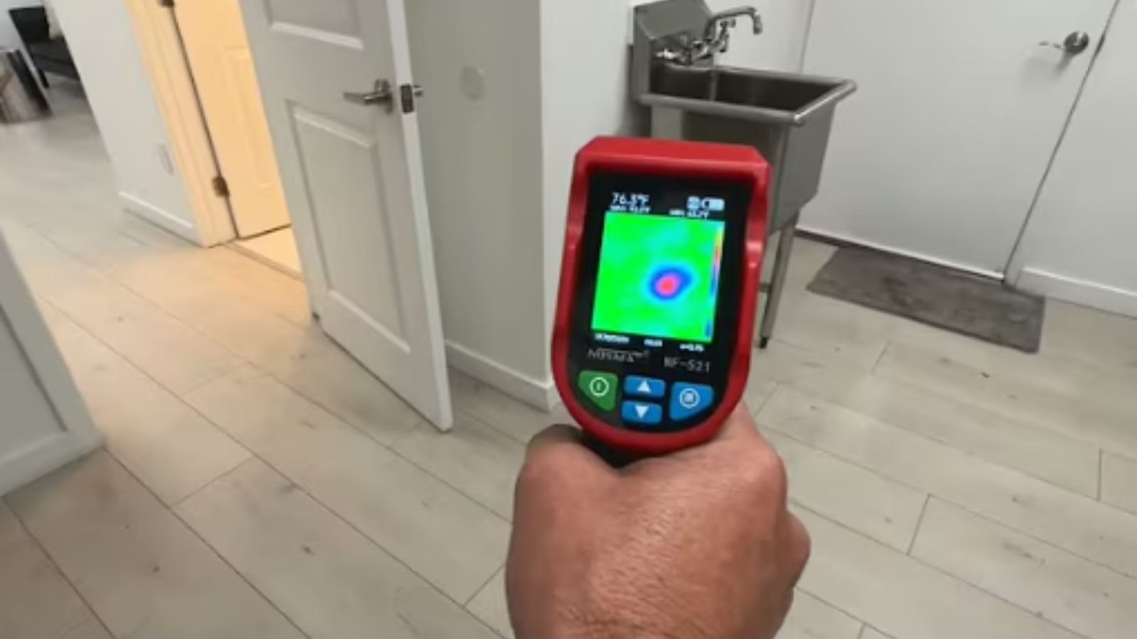 Technician using leak detection equipment on a wall