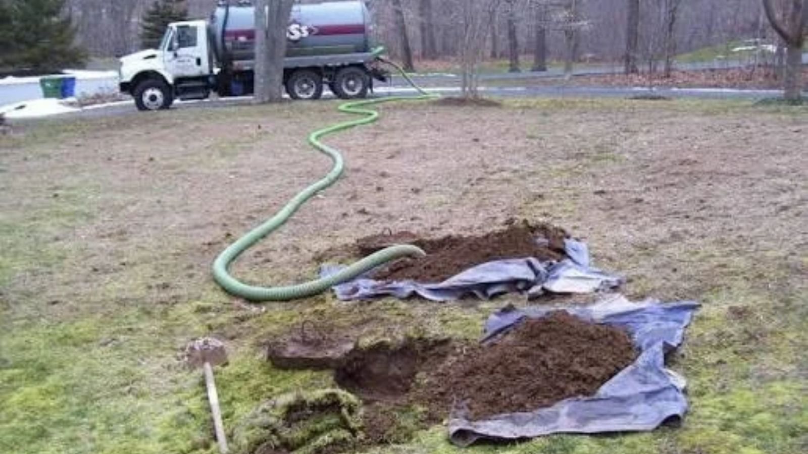 Septic pump-out truck servicing a residential septic tank