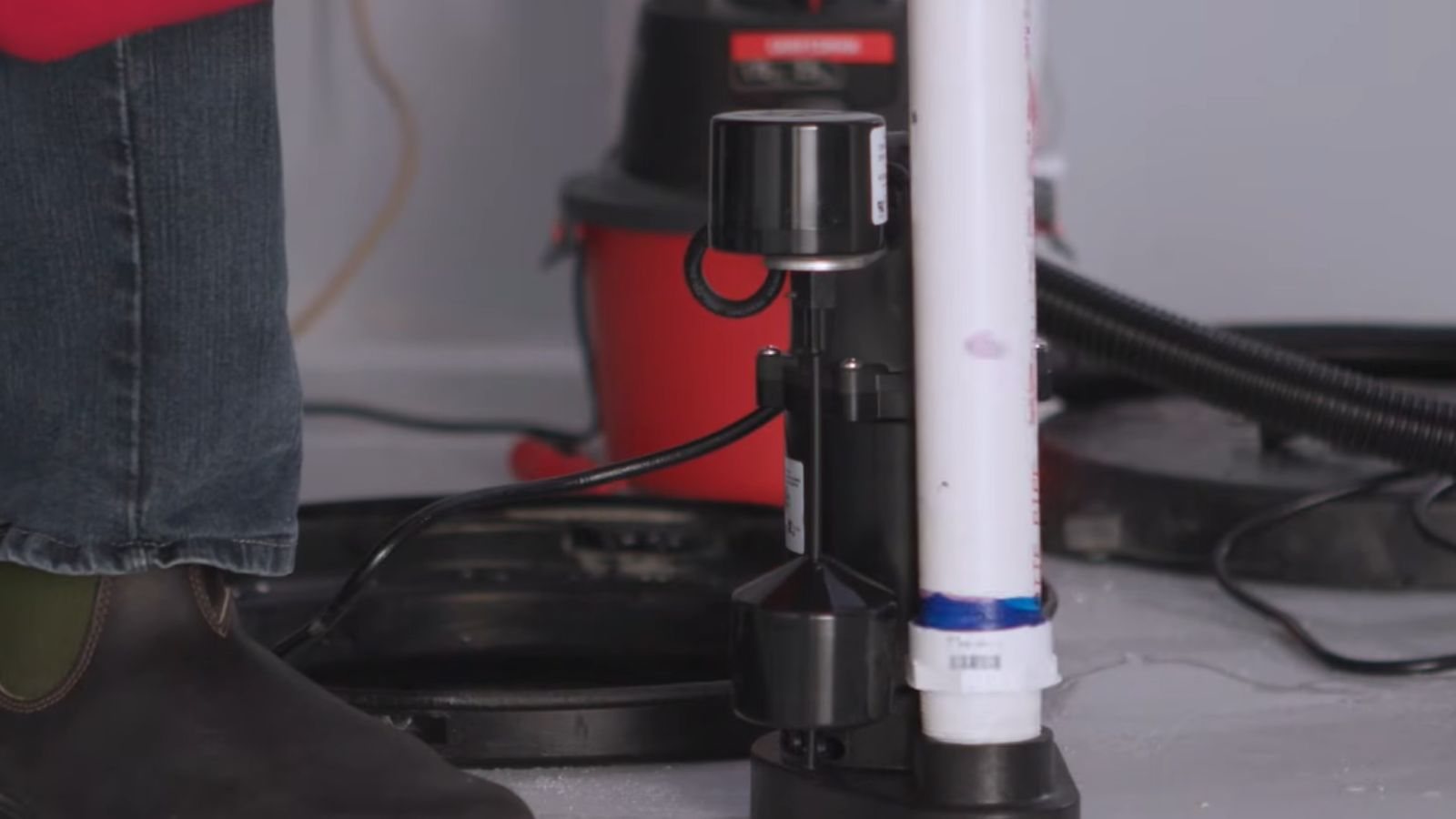 Technician installing a sump pump in a basement
